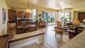A spacious living area with a kitchen, dining table, and seating. - Palms at Wailea Villa 1103 Ocean View 1 BD 2 BA (Wailea)