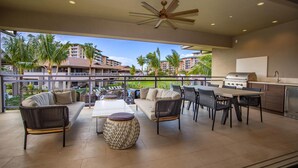 An outdoor patio with a dining area, seating, and a grill.