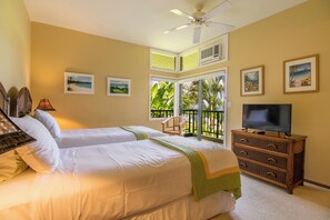 A hotel room with two beds, a television, a ceiling fan, and a balcony with a view of the outdoors.