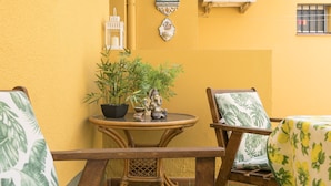 A small outdoor seating area with a round table, two chairs, and a potted plant. - El Cortijo in La Linea de la Conception (La Línea de la Concepción)