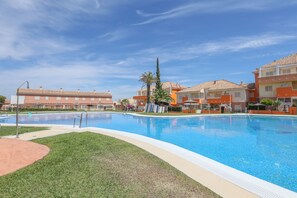 Una piscina rodeada de edificios bajo un cielo azul despejado.