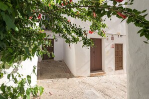 A narrow alleyway with white walls and wooden doors, leading to a courtyard with patterned stone flooring. - Pura Vida in Vejer de la Frontera (Vejer de la Frontera)