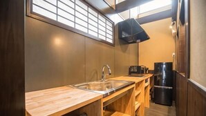 A compact kitchen with a wooden countertop, a sink, a black coffee maker, and a refrigerator. - Kyomachi Rakunan (Kyoto)