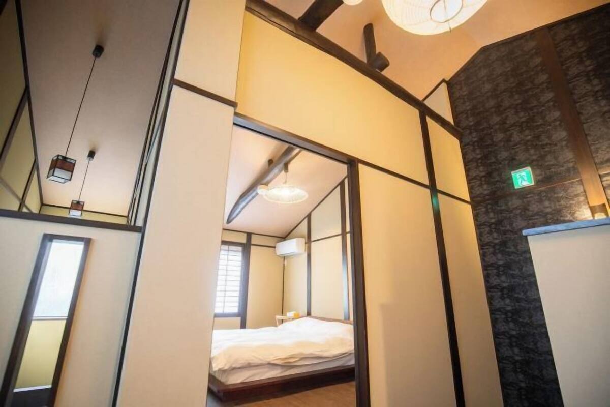 Ein Hotelzimmer mit Bett, Fenster und Wandgerät zur Klimatisierung.