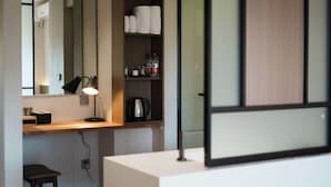 A modern room with a desk, a lamp, a shelf with toiletries, and a large window. - Nanlahe Paya Resort Hotel (Mengla)