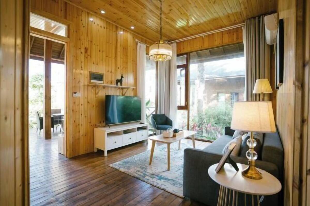 A wooden interior with a sofa, TV, and a small table.