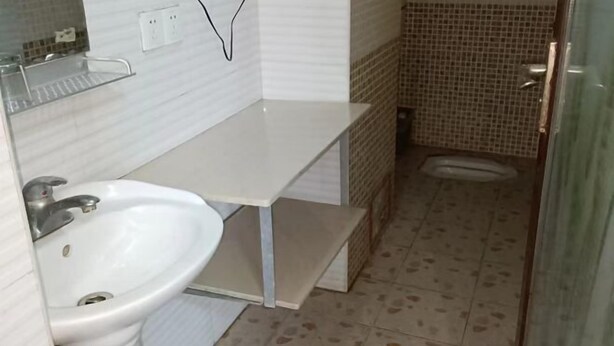 Ein Badezimmer mit weißem Waschbecken, einem Spiegel und einer Duschkabine.