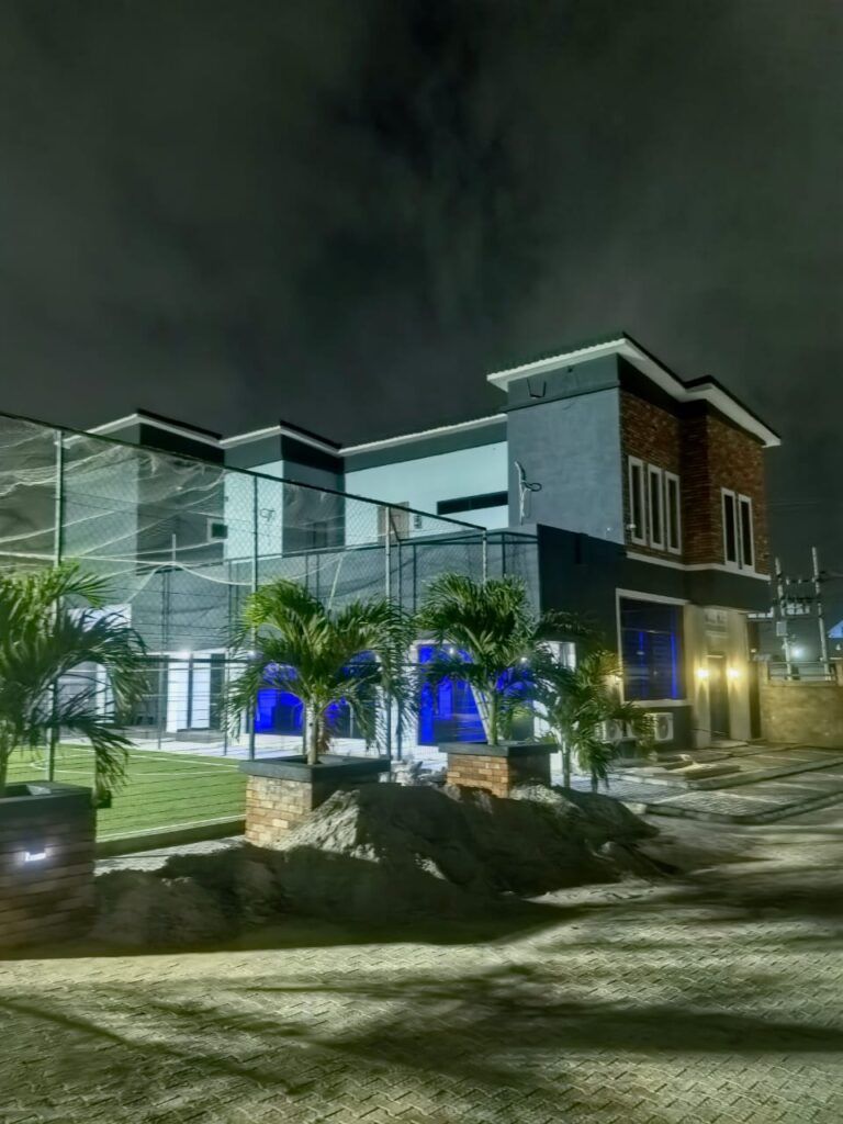 Un edificio moderno con fachada de vidrio, sección de ladrillo y una entrada bien iluminada.