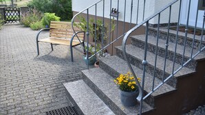 Un escalier en pierre avec des rampes métalliques menant à l’entrée d’un bâtiment.