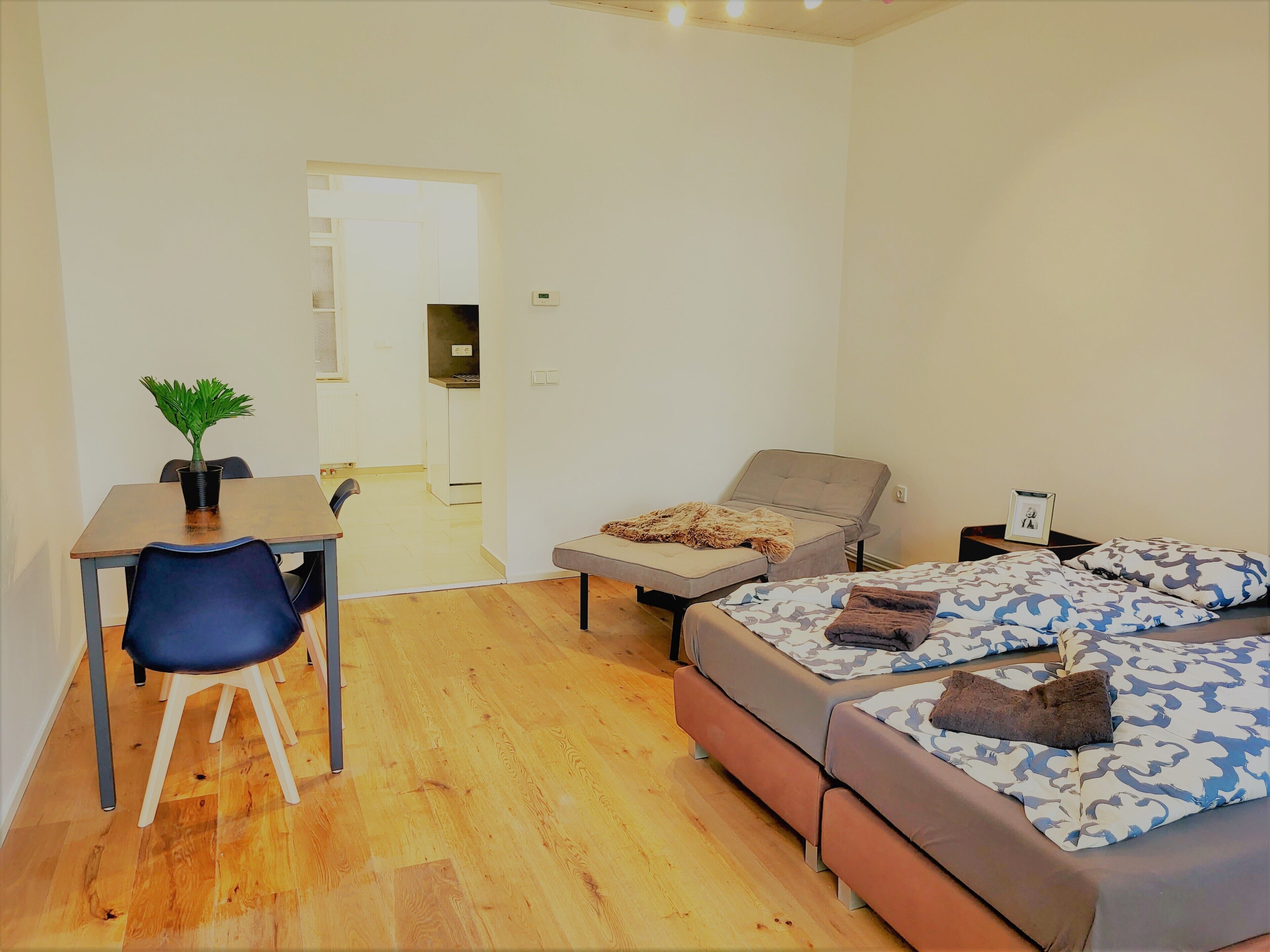 A small, modern room with a bed, a desk, and a chair.