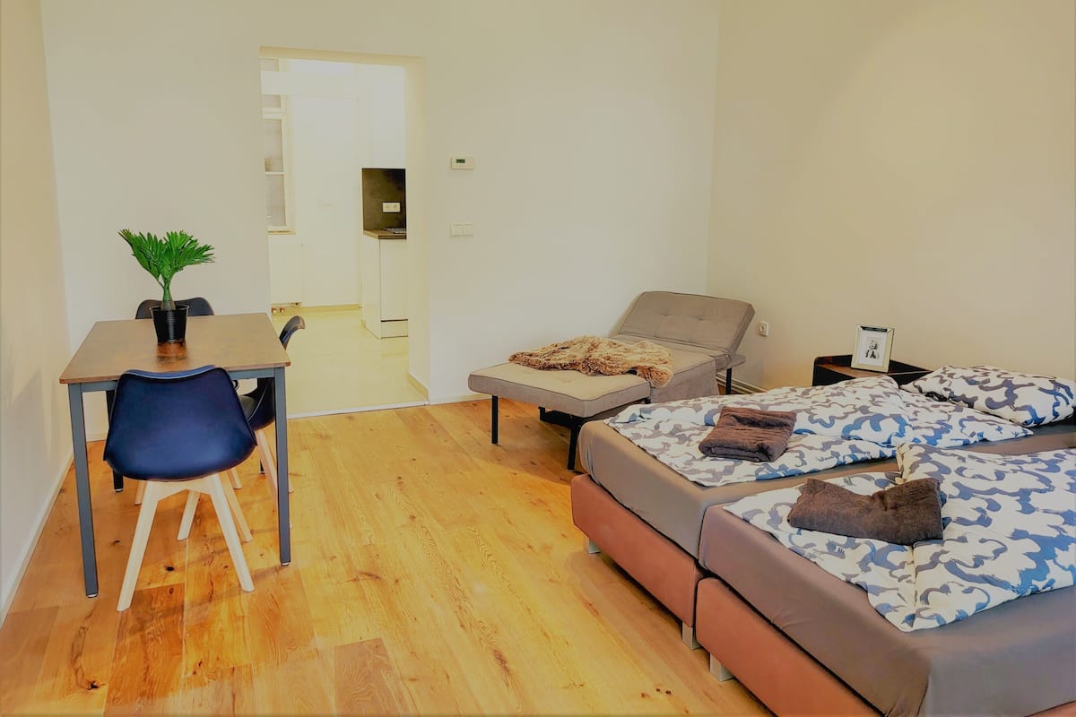 A small, modern room with a bed, a desk, and a chair.