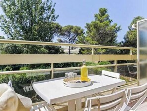 Enjoy al fresco dining on this balcony overlooking a serene landscape with a table set for a meal.