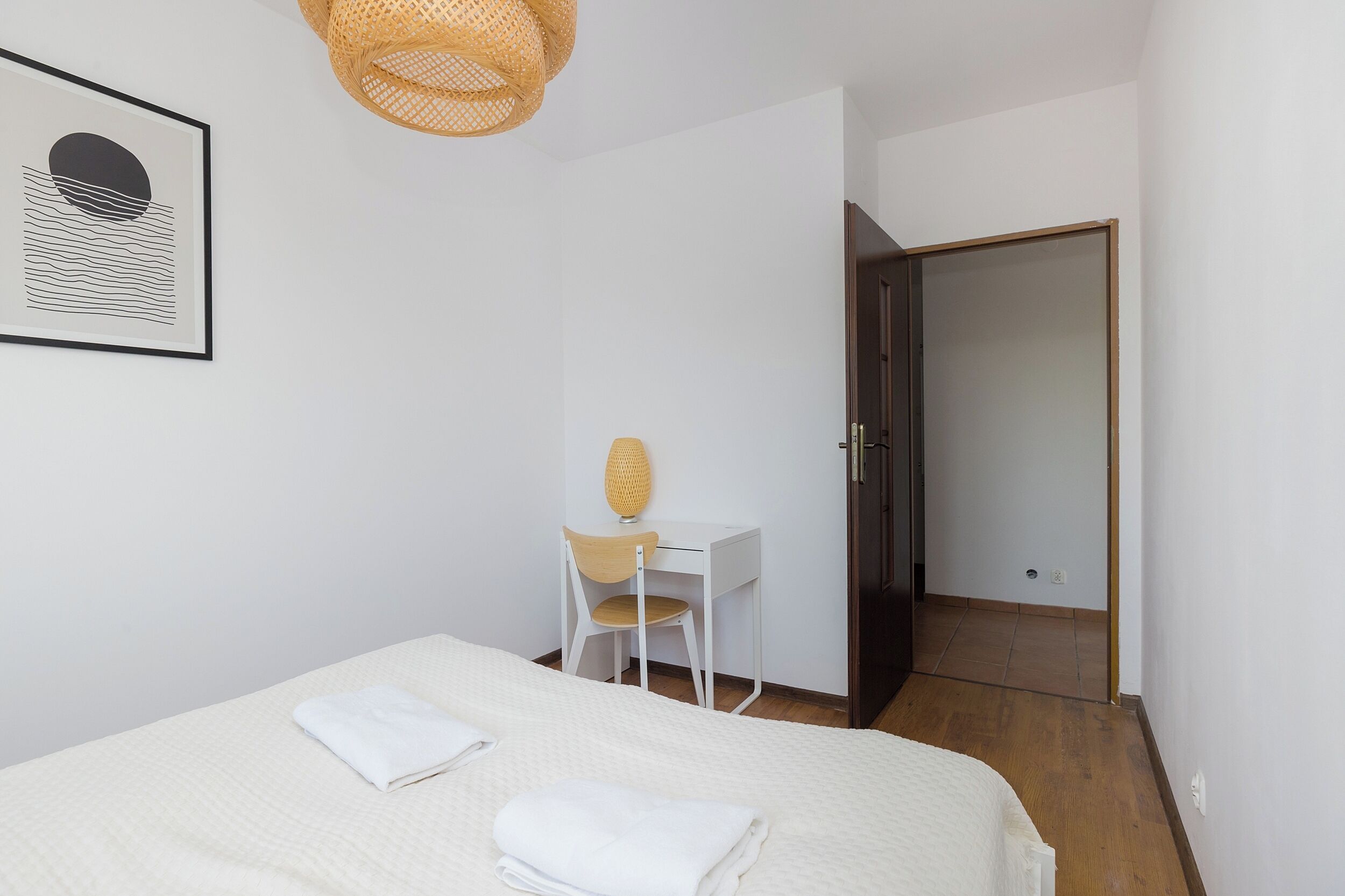 Une chambre à coucher avec un lit, un bureau, une chaise et une porte.