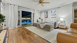 Una sala de estar moderna con un sofá, una mesa de centro y vistas a la piscina.
