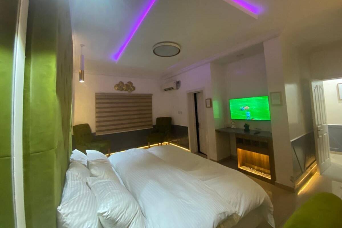 A hotel room with a bed, a television, and a seating area with a fireplace.