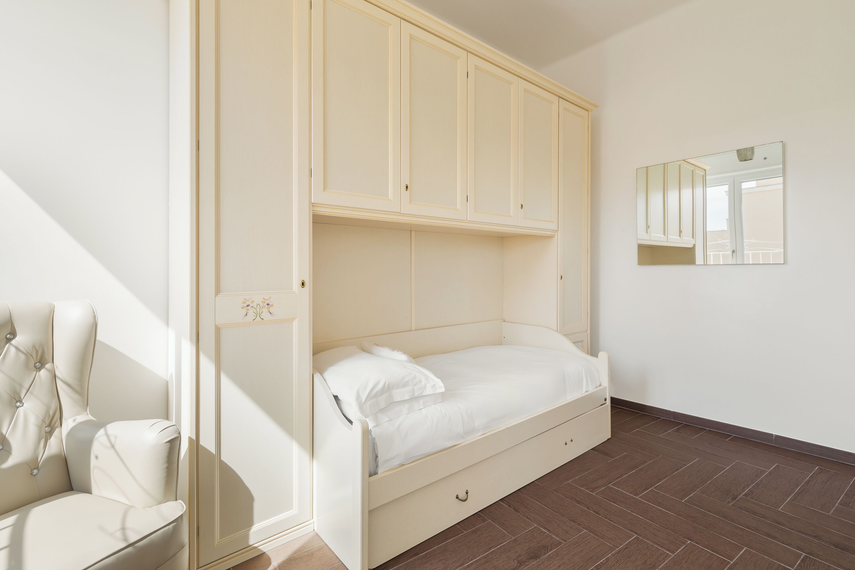 Une chambre à coucher avec un lit, une armoire et un miroir.