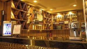 A bar area with shelves of bottles and a coffee machine. - EdisPremier Hotel & Suites (Port Harcourt)