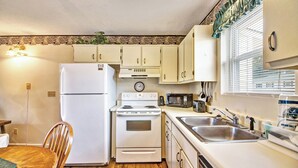 Une cuisine de taille réduite équipée d’un réfrigérateur, d’une cuisinière, d’un four à micro-ondes et d’un évier.