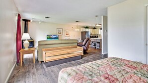 Habitació d'hotel senzilla amb un llit, un sofà, zona de menjador i petita cuina.