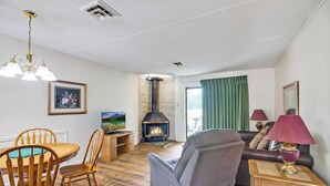 Una sala de estar con chimenea, muebles de madera y televisor.