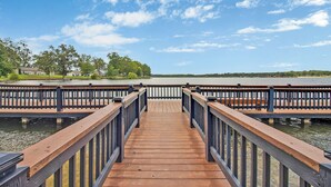 Un muelle de madera que conduce a un lago tranquilo con cielo despejado.