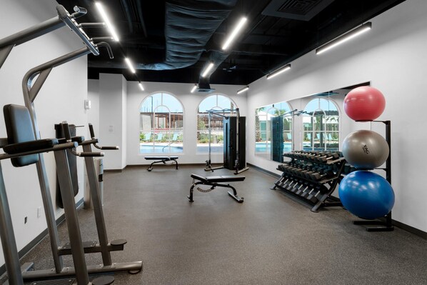 A gym with treadmills, weight machines, and exercise balls.