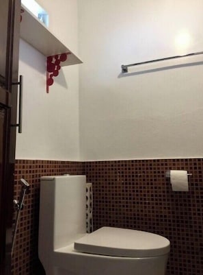 Een douche, handdoeken, zeep, toiletpapier