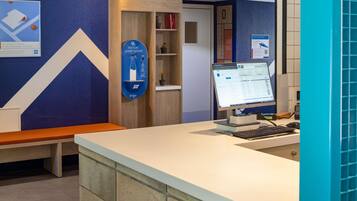 A reception desk with a computer monitor, a sign for 'Potion Smart Sport,' and a blue wall with a geometric design.