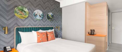 Una habitación de hotel moderna con una cama grande, un escritorio y un armario.