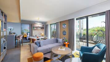 Deluxe Suite, 1 Double Bed, Balcony | Living area | 50-inch Smart TV with cable channels, books