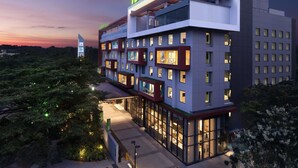 Ein mehrstöckiges Hotel mit einem gut sichtbaren 'ibis Styles'-Schild, großen Fenstern und einem modernen architektonischen Design.