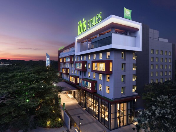 Ein mehrstöckiges Hotel mit einem gut sichtbaren 'ibis Styles'-Schild, großen Fenstern und einem modernen architektonischen Design.