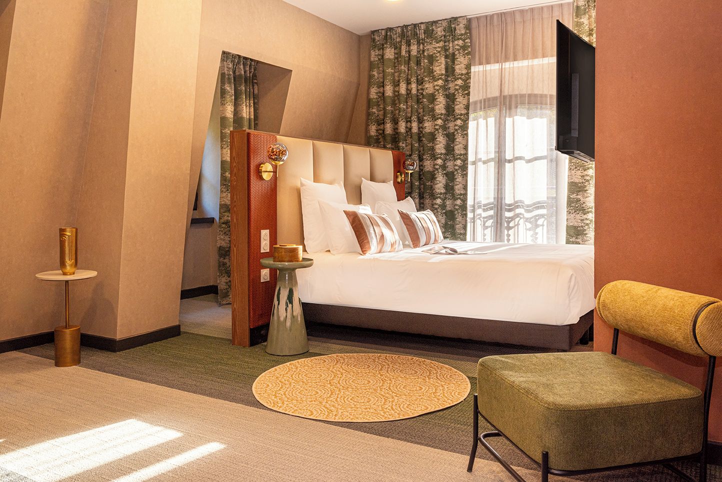 A hotel room with a large bed, a television, a small table, and a chair.