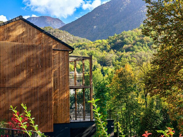A wooden cabin with a balcony overlooking a forested valley and mountains. - Mercure Ax Les Thermes (Ax-les-Thermes)