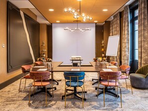 A conference room with a large table, chairs, a projector, and a whiteboard. - Mercure Ax Les Thermes (Ax-les-Thermes)