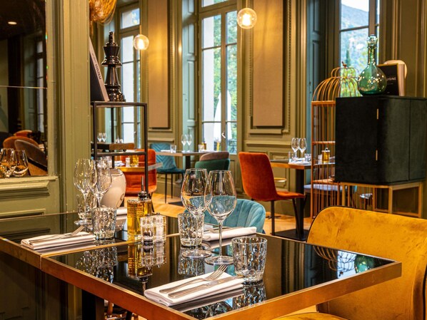 A dining area with a table set for a meal, surrounded by chairs. - Mercure Ax Les Thermes (Ax-les-Thermes)