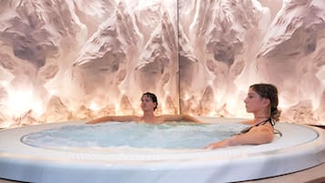 A hot tub with a mountainous wall backdrop.