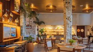 Un restaurante con paredes de madera, pilares de piedra y diferentes opciones de asientos.