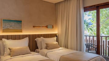 A hotel room with two beds, a wooden headboard, a painting of a beach, and a view of a balcony with a chair.
