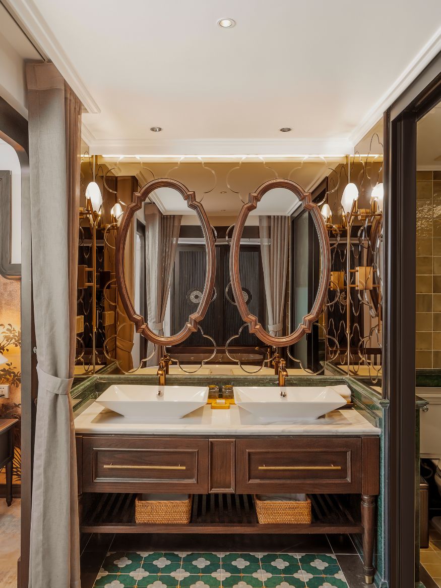 A bathroom with a double vanity, two large mirrors, and a decorative light fixture.