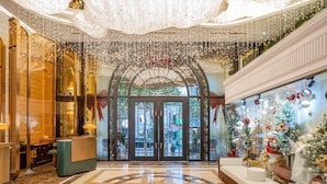 A lobby with a grand entrance, a glass door, and a Christmas display. - Rue de L'amour Boutique Hotel (Hanoi)