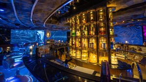 A bar area with a modern design, featuring a large display screen and multiple shelves of bottles. - Rue de L'amour Boutique Hotel (Hanoi)