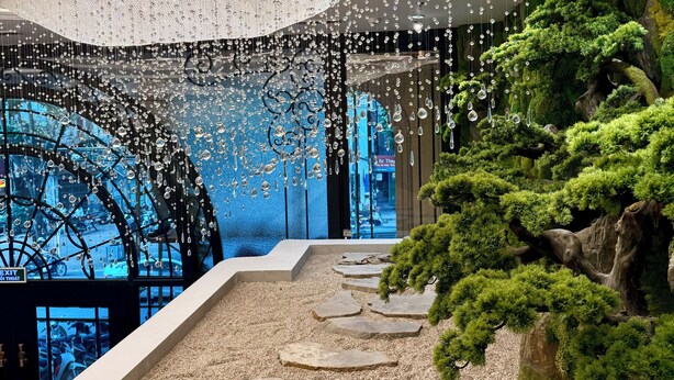 A modern interior with a decorative ceiling, a pathway with stepping stones, and a green, mossy area. - Rue de L'amour Boutique Hotel (Hanoi)