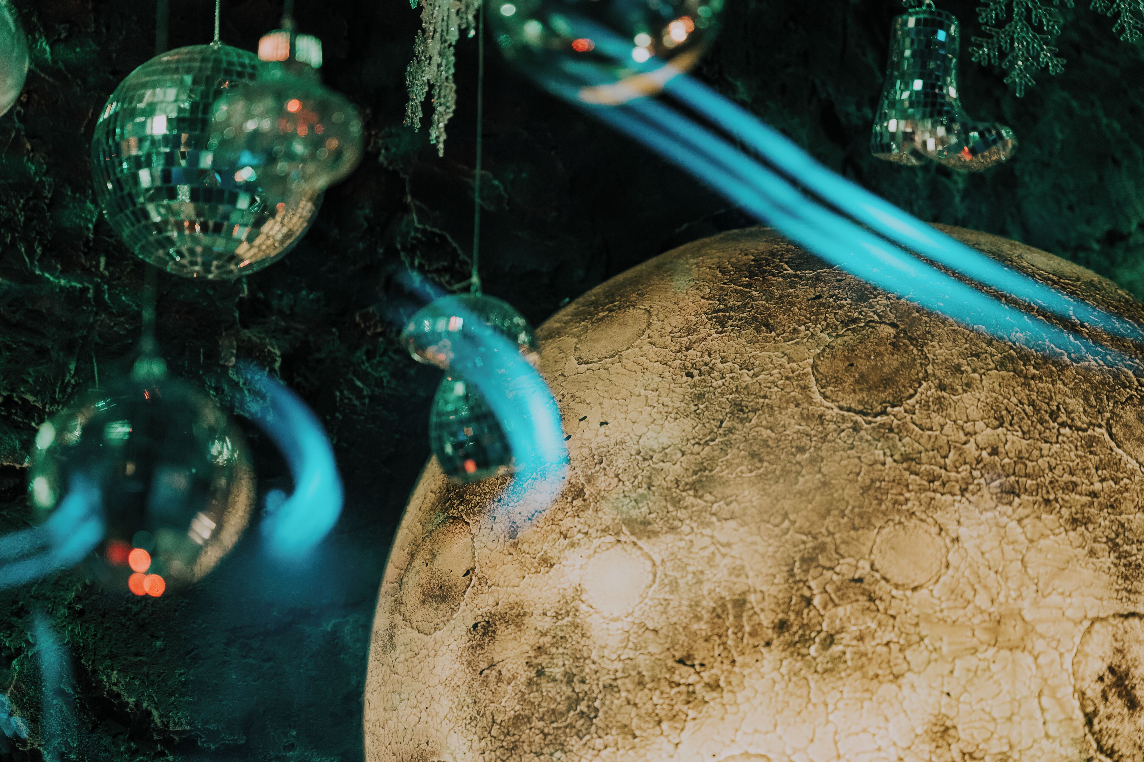 A close-up of a textured spherical object, possibly a decorative item, with reflective surfaces and hanging elements.
