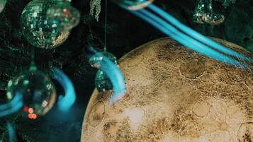 A close-up of a textured spherical object, possibly a decorative item, with reflective surfaces and hanging elements.