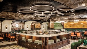 A restaurant with a central bar area, multiple dining tables, and a patterned floor. - Rue de L'amour Boutique Hotel (Hanoi)