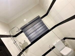 A modern bathroom with a shower, toilet, and a towel rack. - Lylius Hotel (Ilorin)