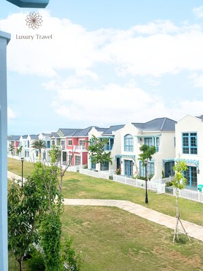A row of colorful houses with a white picket fence and a clear sky. - Nova Oasis Villas Sea View Phan Thiet By An Gia Hospitality (Tien Thanh)