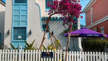 A white building with blue accents, a white picket fence, and a sign for 'Luxury Travel'.