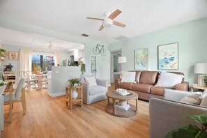 Ein geräumiges Wohnzimmer mit Essbereich, Küche und Deckenventilator.